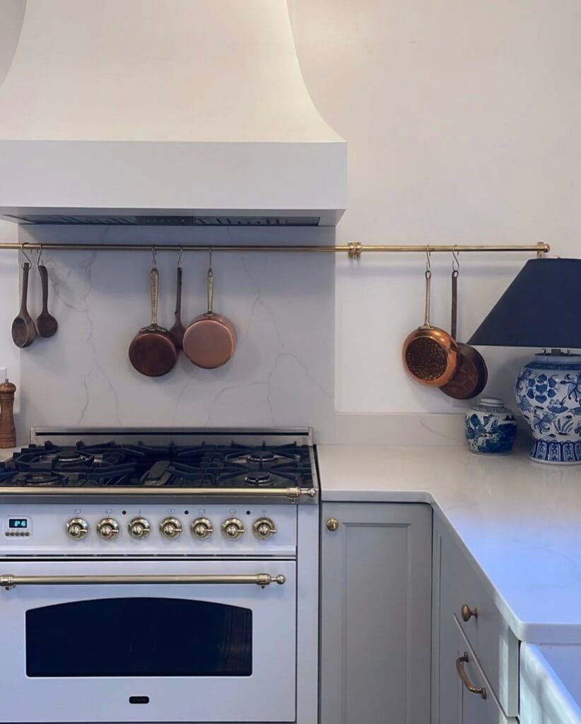 Functionally designed kitchen with pot racks, lamp, and well thought out layout.