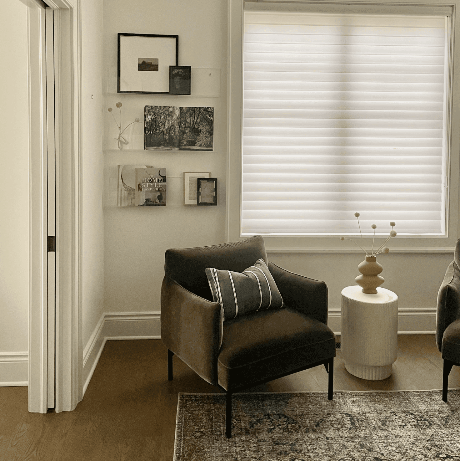 Green chairs, white side table, curated and organized art, and white shades. Interior Design Services to provide exclusive furniture layout.
